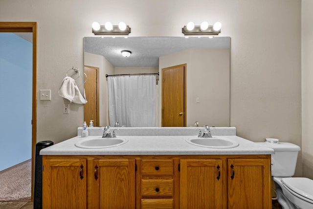 bathroom featuring vanity, toilet, and curtained shower