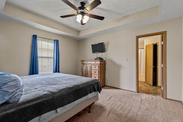 bedroom with ceiling fan, a textured ceiling, a raised ceiling, and light carpet