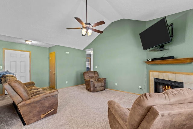 living room with ceiling fan, lofted ceiling, a tiled fireplace, and carpet