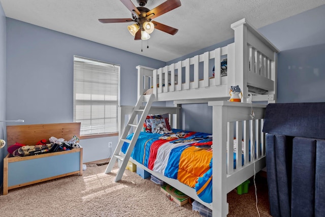 bedroom with carpet, a textured ceiling, and ceiling fan