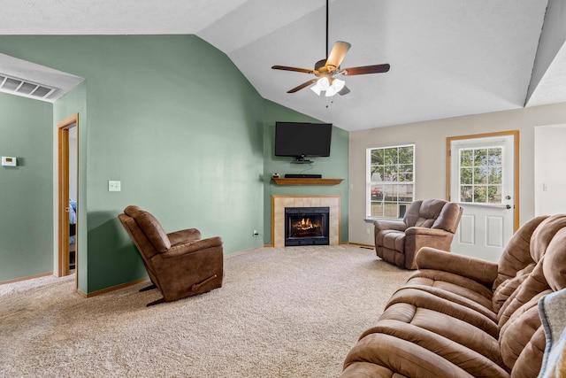 carpeted living room with a fireplace, vaulted ceiling, and ceiling fan