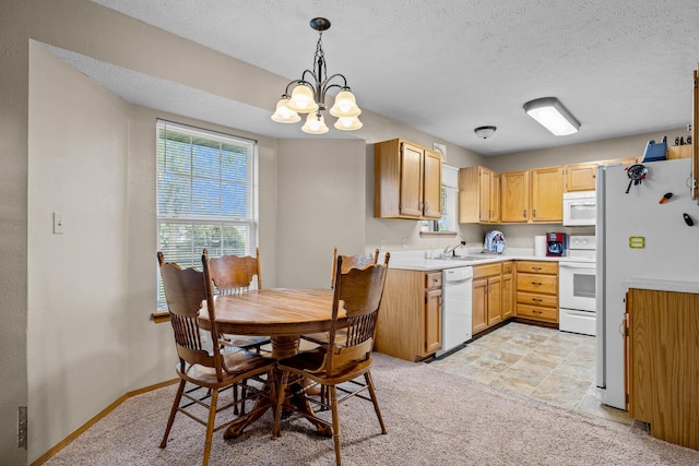 kitchen with pendant lighting, a textured ceiling, a chandelier, and white appliances