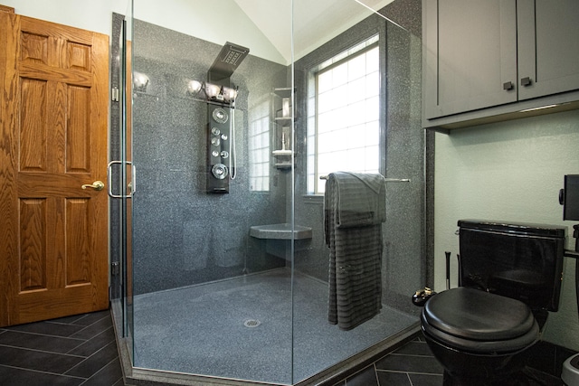 bathroom with lofted ceiling, a shower with shower door, toilet, and tile patterned floors