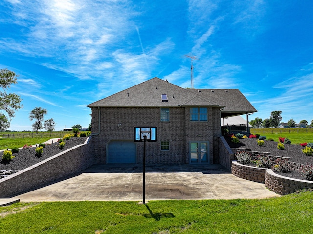 back of house with a garage and a yard