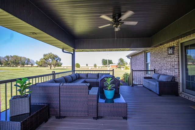 wooden deck with outdoor lounge area, a yard, and ceiling fan