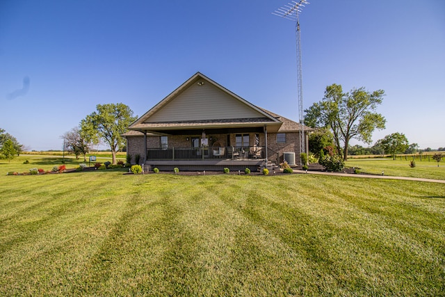 rear view of property featuring a yard, central AC, and a rural view