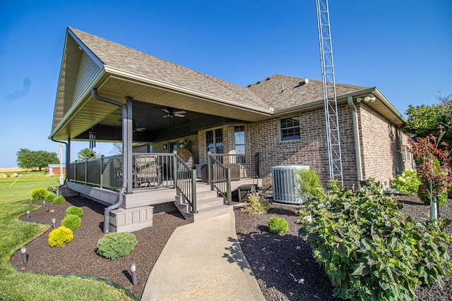 rear view of house with ceiling fan, a deck, a lawn, and central AC