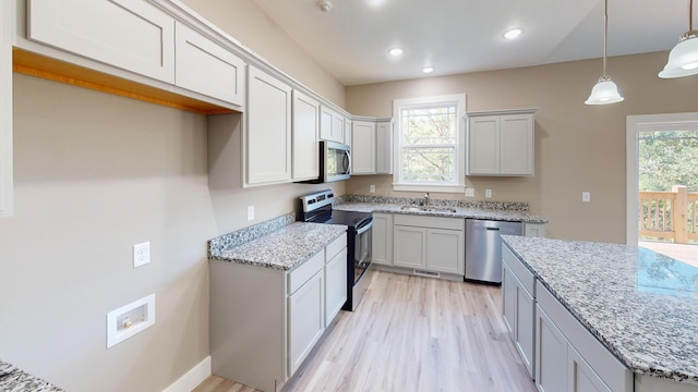 500 Timber Wolf Rd, Hollister, MO 65672 - kitchen with light wood-style flooring, a sink, light stone counters, and appliances with stainless steel finishes