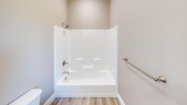 500 Timber Wolf Rd, Hollister, MO 65672 - bathroom with toilet, shower / washtub combination, wood finished floors, and baseboards