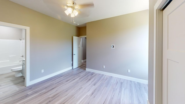 500 Timber Wolf Rd, Hollister, MO 65672 - unfurnished bedroom with ensuite bath, baseboards, ceiling fan, and light wood-style floors