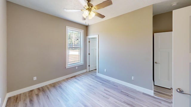 500 Timber Wolf Rd, Hollister, MO 65672 - unfurnished bedroom with baseboards, a ceiling fan, and light wood-style floors