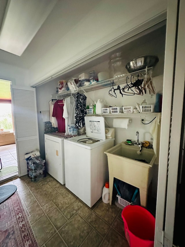 laundry room with sink, dark tile patterned flooring, and washer and clothes dryer