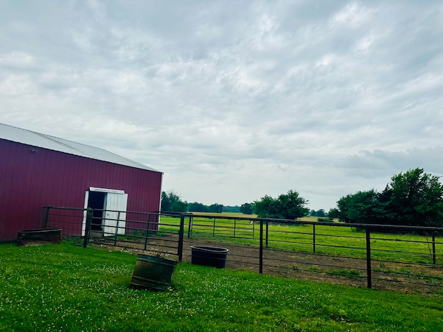 view of yard featuring a rural view and an outbuilding