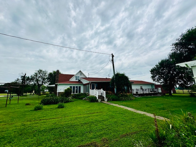 view of front facade featuring a deck and a front lawn