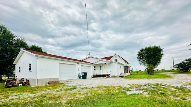 back of property with a garage and a yard