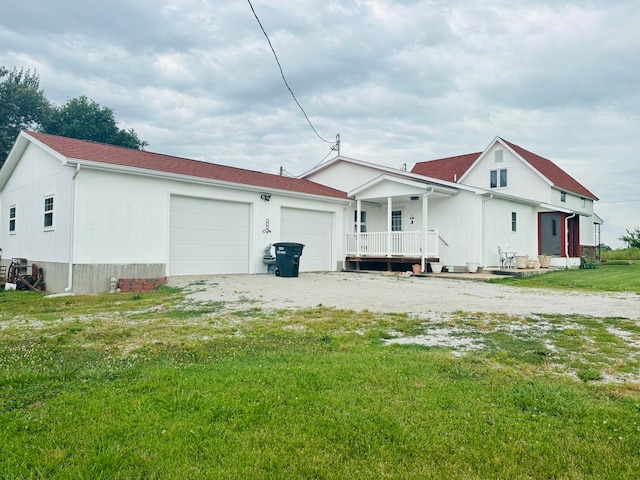 rear view of house with a yard, a porch, and a garage