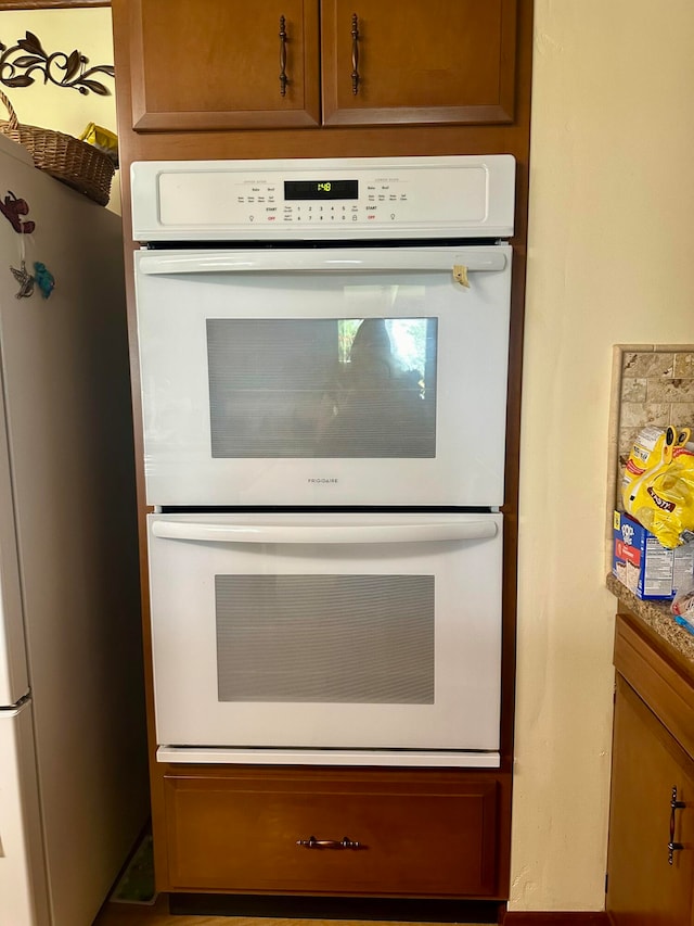 kitchen with double oven and stainless steel refrigerator