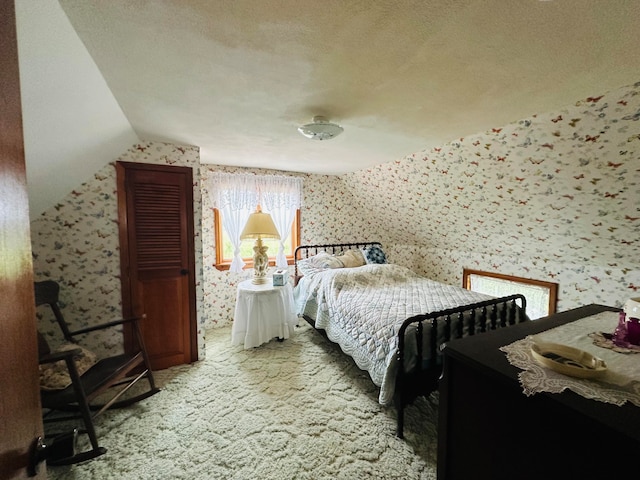 bedroom featuring a textured ceiling, multiple windows, vaulted ceiling, and carpet