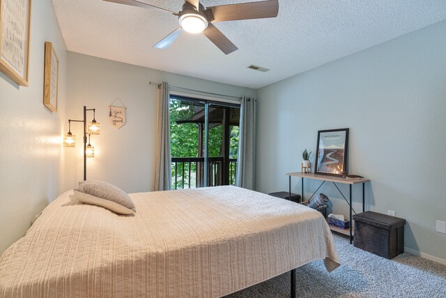 carpeted bedroom with access to outside, a textured ceiling, and ceiling fan