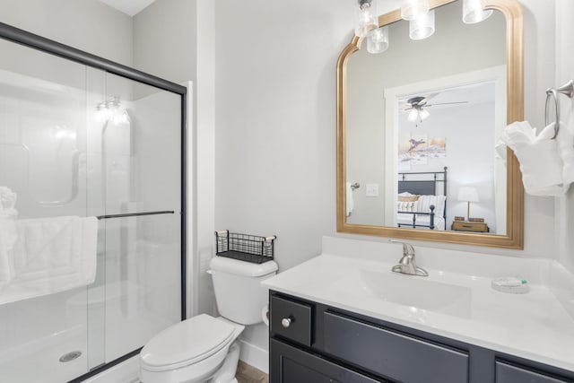 bathroom with ceiling fan, a shower with shower door, vanity, and toilet