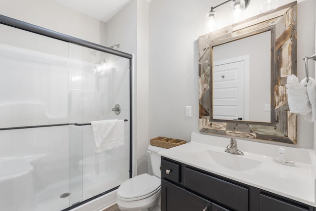 bathroom with vanity, toilet, and a shower with shower door