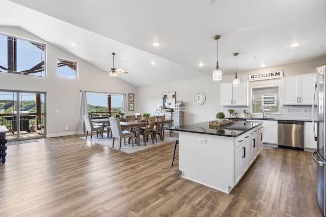 kitchen with hanging light fixtures, wood-type flooring, white cabinetry, dishwasher, and a center island