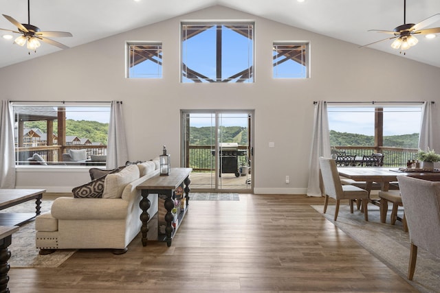 living room with plenty of natural light, high vaulted ceiling, and hardwood / wood-style flooring