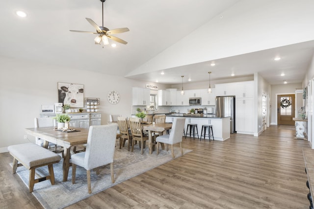 dining room with high vaulted ceiling, light wood-type flooring, and ceiling fan