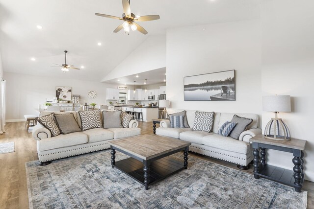 living room featuring high vaulted ceiling, hardwood / wood-style floors, and ceiling fan