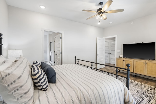 bedroom featuring ceiling fan, ensuite bathroom, and dark wood-type flooring