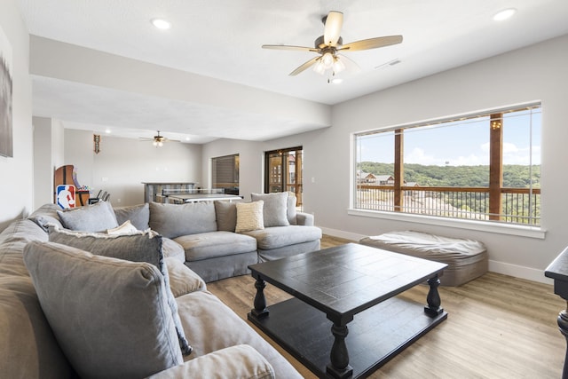 living room featuring ceiling fan and light hardwood / wood-style flooring