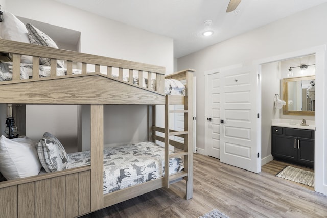 bedroom featuring ceiling fan, light wood-type flooring, and ensuite bathroom