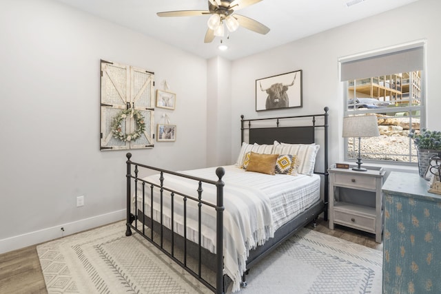 bedroom with light hardwood / wood-style floors and ceiling fan