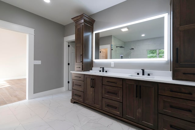 bathroom featuring ornate columns, tiled shower, and vanity