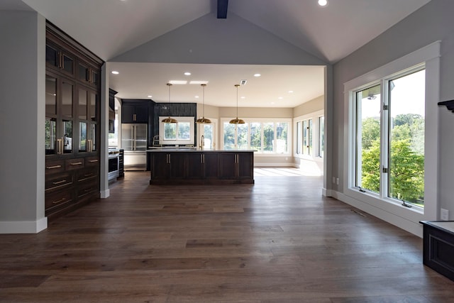 kitchen with lofted ceiling with beams, a kitchen island, stainless steel appliances, and dark hardwood / wood-style flooring