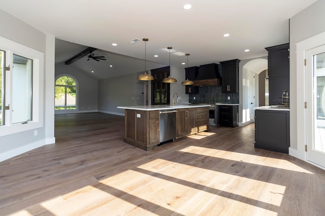 kitchen with an island with sink, decorative light fixtures, hardwood / wood-style floors, and dishwasher