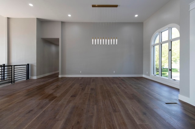 spare room with a wealth of natural light and dark hardwood / wood-style floors