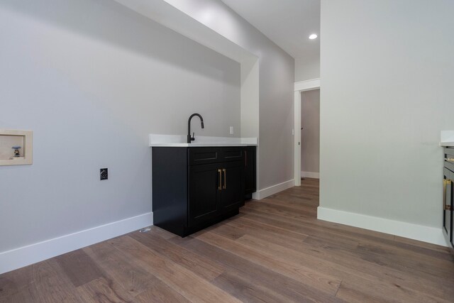 bar with sink and light hardwood / wood-style floors