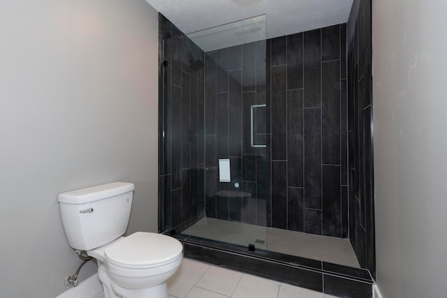 bathroom with a tile shower, tile patterned floors, a textured ceiling, and toilet