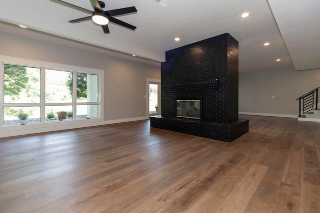 unfurnished living room with hardwood / wood-style flooring, a fireplace, and a healthy amount of sunlight