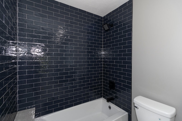 bathroom with tiled shower / bath, a textured ceiling, and toilet