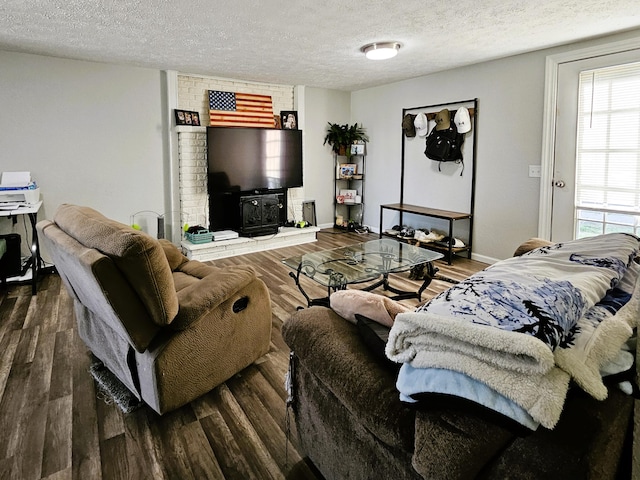 living room featuring dark hardwood / wood-style floors, a textured ceiling, and a wood stove