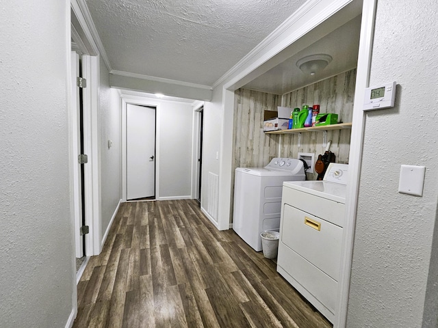 laundry room with a textured ceiling, dark hardwood / wood-style floors, ornamental molding, and washing machine and clothes dryer