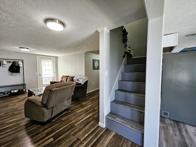 stairs featuring wood-type flooring and a textured ceiling