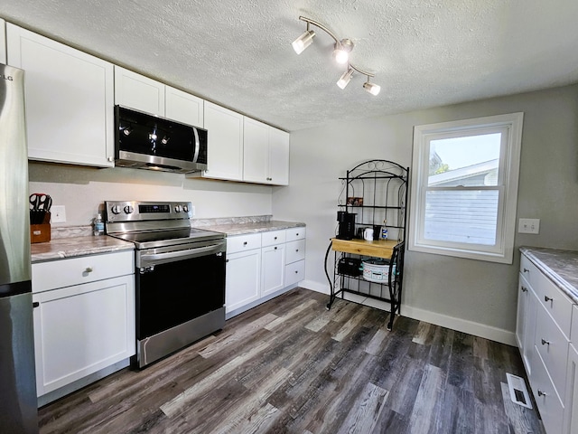 kitchen featuring rail lighting, dark hardwood / wood-style flooring, white cabinetry, appliances with stainless steel finishes, and a textured ceiling