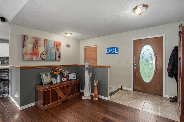 entryway featuring wood-type flooring and a textured ceiling