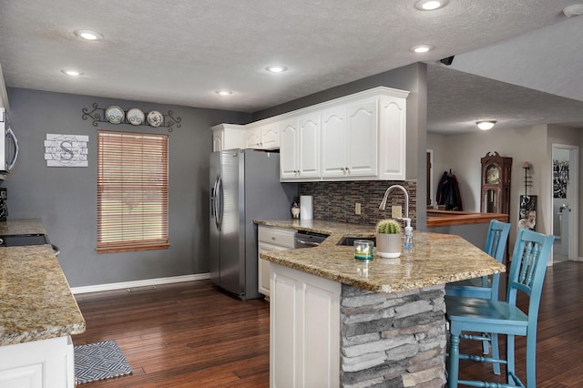 kitchen featuring light stone counters, white cabinetry, and dark hardwood / wood-style floors