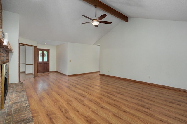 unfurnished living room featuring ceiling fan, french doors, lofted ceiling with beams, a fireplace, and light hardwood / wood-style floors