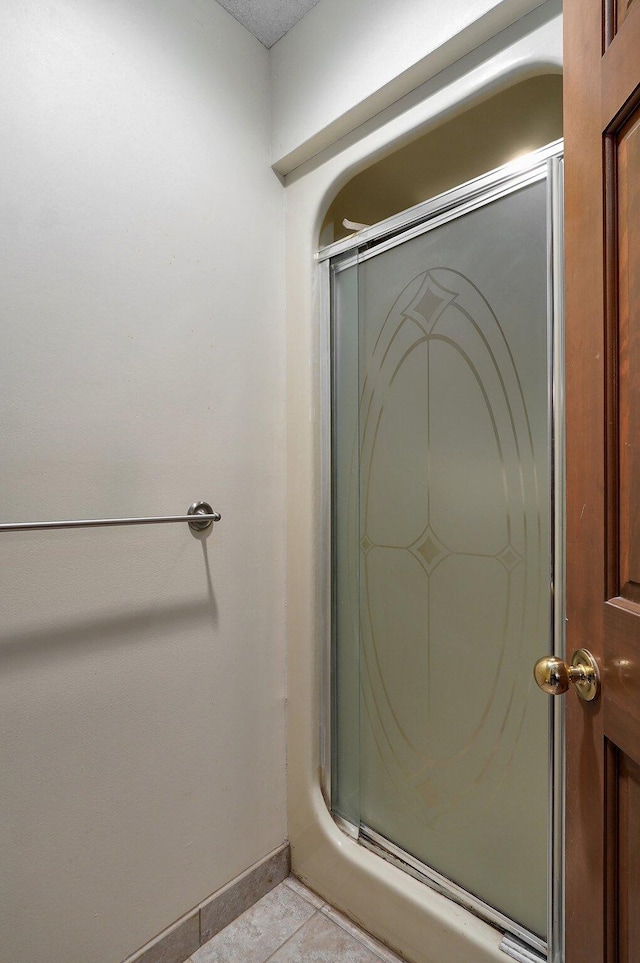 bathroom with tile patterned flooring and an enclosed shower