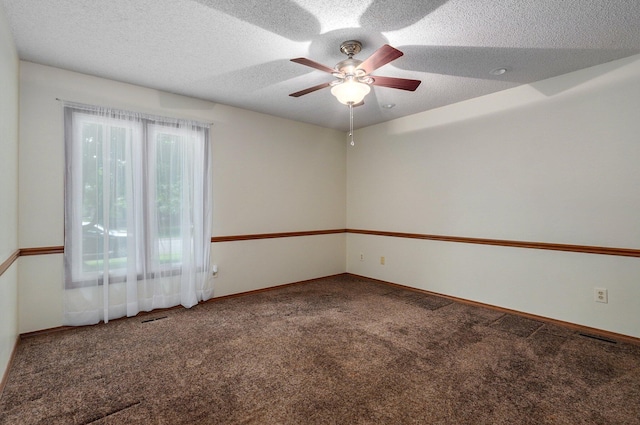 spare room featuring ceiling fan, a textured ceiling, and carpet